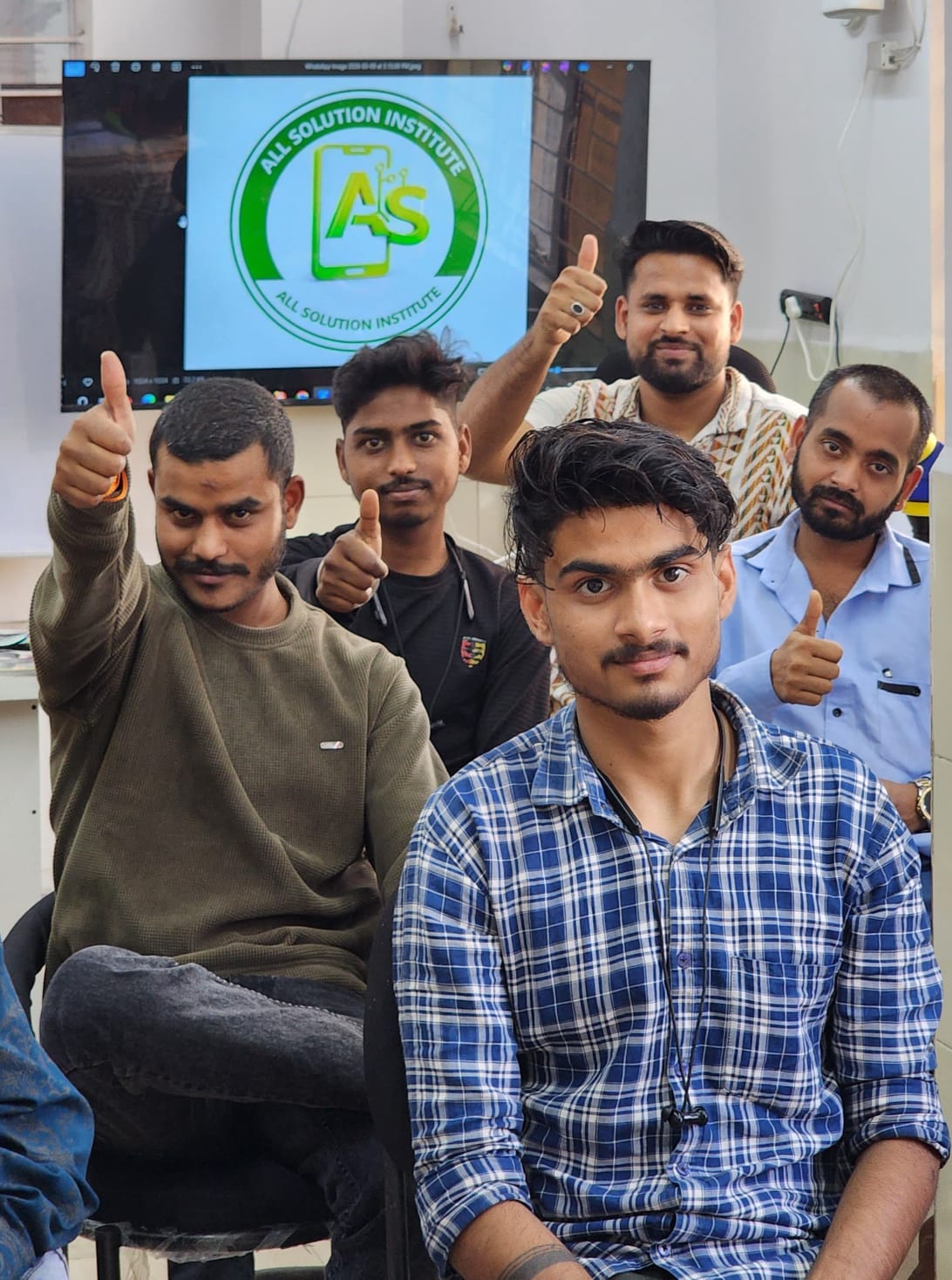 Happy students giving a thumbs up in the classroom